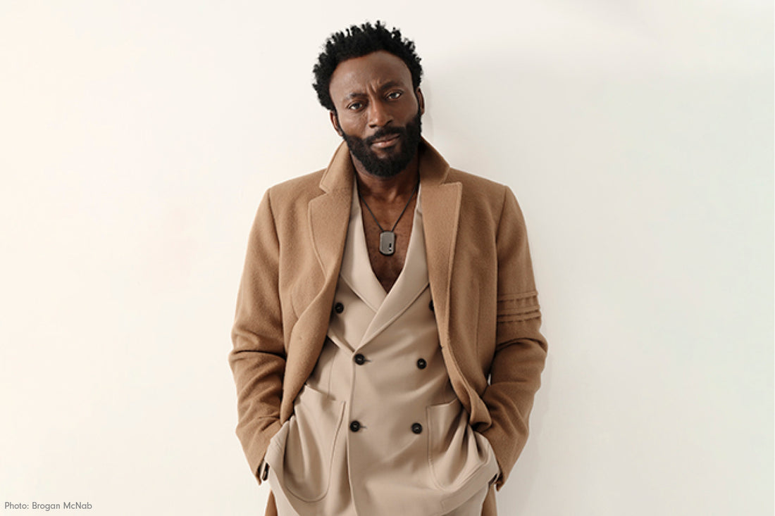 Nigerian-American actor Babs Olusankmokun is wearing the SENTALER Men Technical Baby Alpaca Notched Lapel Overcoat in Dark Camel.