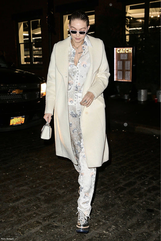 American model and television personality Gigi Hadid is wearing the SENTALER Classic Long Coat with Shawl Collar in Ivory at night in the streets of New York.