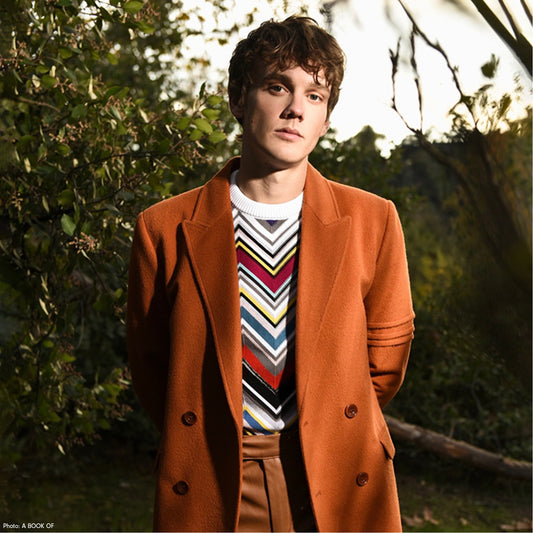 American actor, writer and director Hunter Doohan is wearing the SENTALER Men Technical Baby Alpaca Double Breasted Overcoat in Burnt Orange outside for the cover of "A BOOK OF Magazine." 