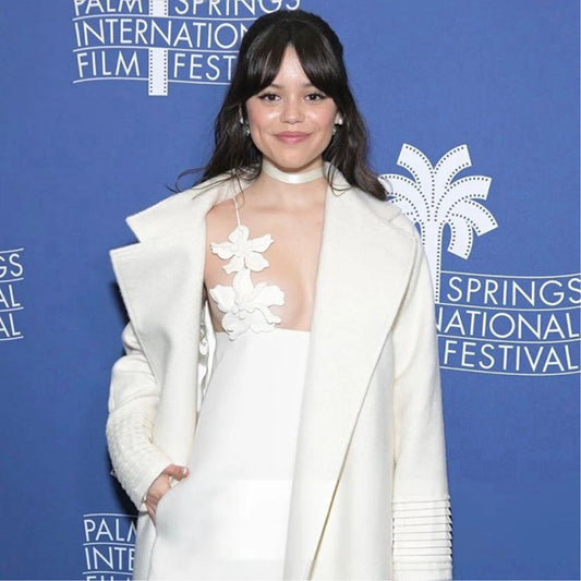 American actress Jenna Ortega is wearing the SENTALER Long Notched Collar Raglan Sleeve Wrap Coat in Ivory.