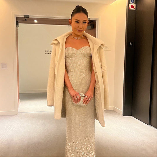 American actress Li Jun Li is wearing the SENTALER SENTALER Men Technical Bouclé Alpaca Double Collar Topcoat in Ivory with a white gown on her way to the 80th Annual Golden Globe Awards.