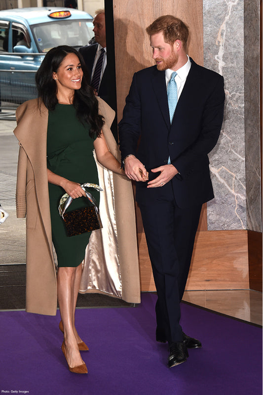 The Duchess of Sussex Meghan Markle is wearing the SENTALER Long Wide Collar Wrap Coat in Camel walking in to the Annual WellChild Awards with Prince Harry.