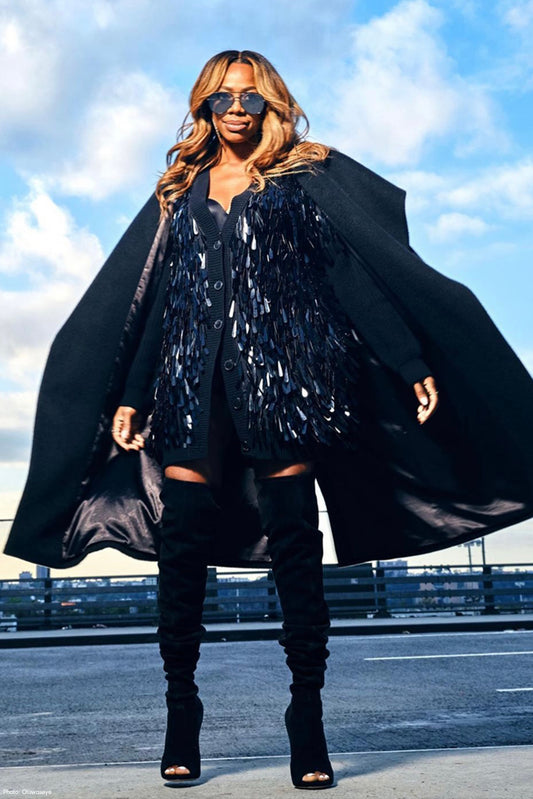 Nigerian-American actress and comedian Yvonne Orji is wearing the SENTALER Suri Alpaca Long Wide Shawl Collar Wrap Coat in Black posing on the streets of New York.