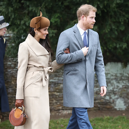 Image features the Glamour logo and an image of the Duchess of Cambridge, Meghan Markle wearing the Sentaler Long Wide Collar Wrap Coat featured in Baby Alpaca and available in Camel alongside Prince Harry.