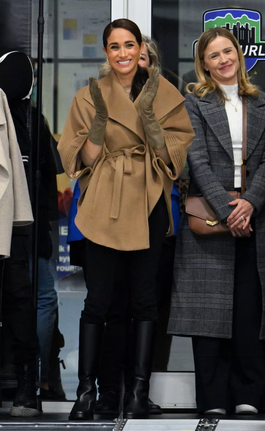 Image features the Harper's Bazaar logo and the Duchess of Sussex, Meghan Markle wearing the Baby Alpaca Cape with Shawl Collar and Belt featured in Baby Alpaca and available in Dark Camel.