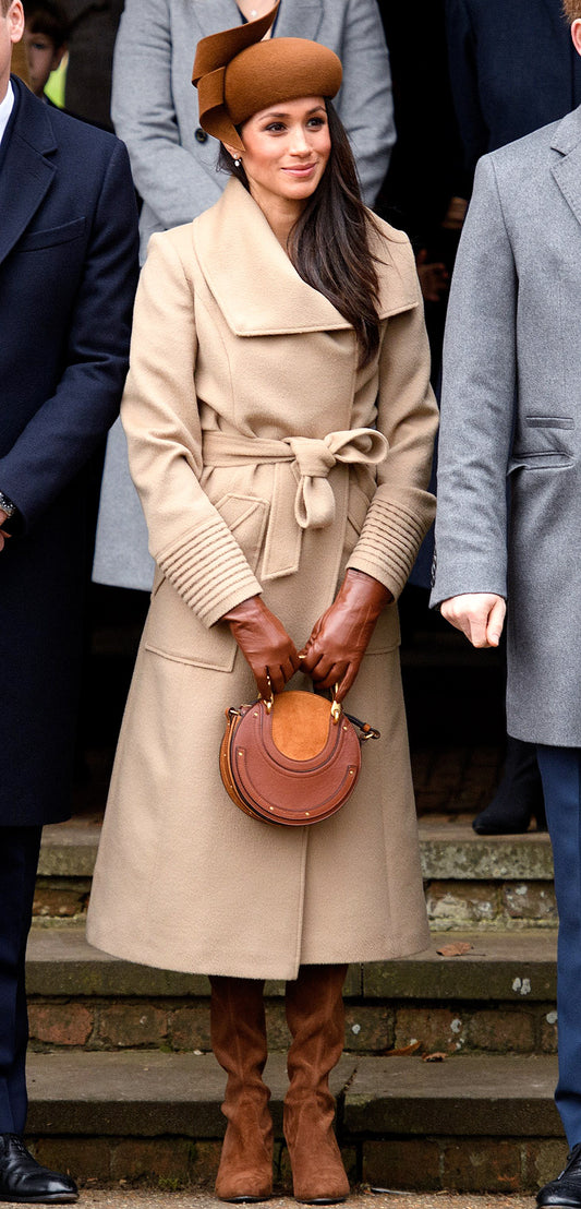 Image features the People logo and an image of the Duchess of Cambridge, Meghan Markle wearing the Sentaler Long Wide Collar Wrap Coat featured in Baby Alpaca and available in Camel.