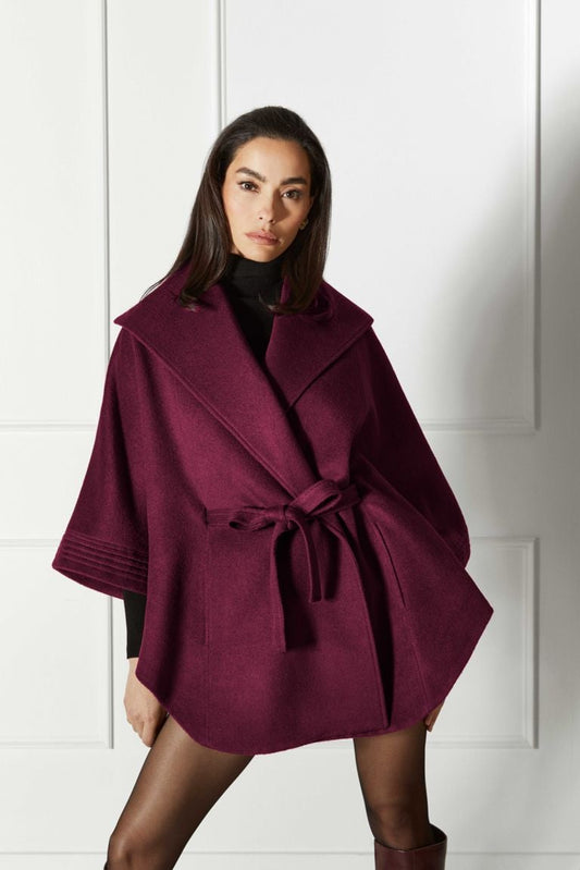 Front view of model wearing a Sentaler cherry lacquer cape made of baby alpaca wool, with a shawl collar, worn belted.