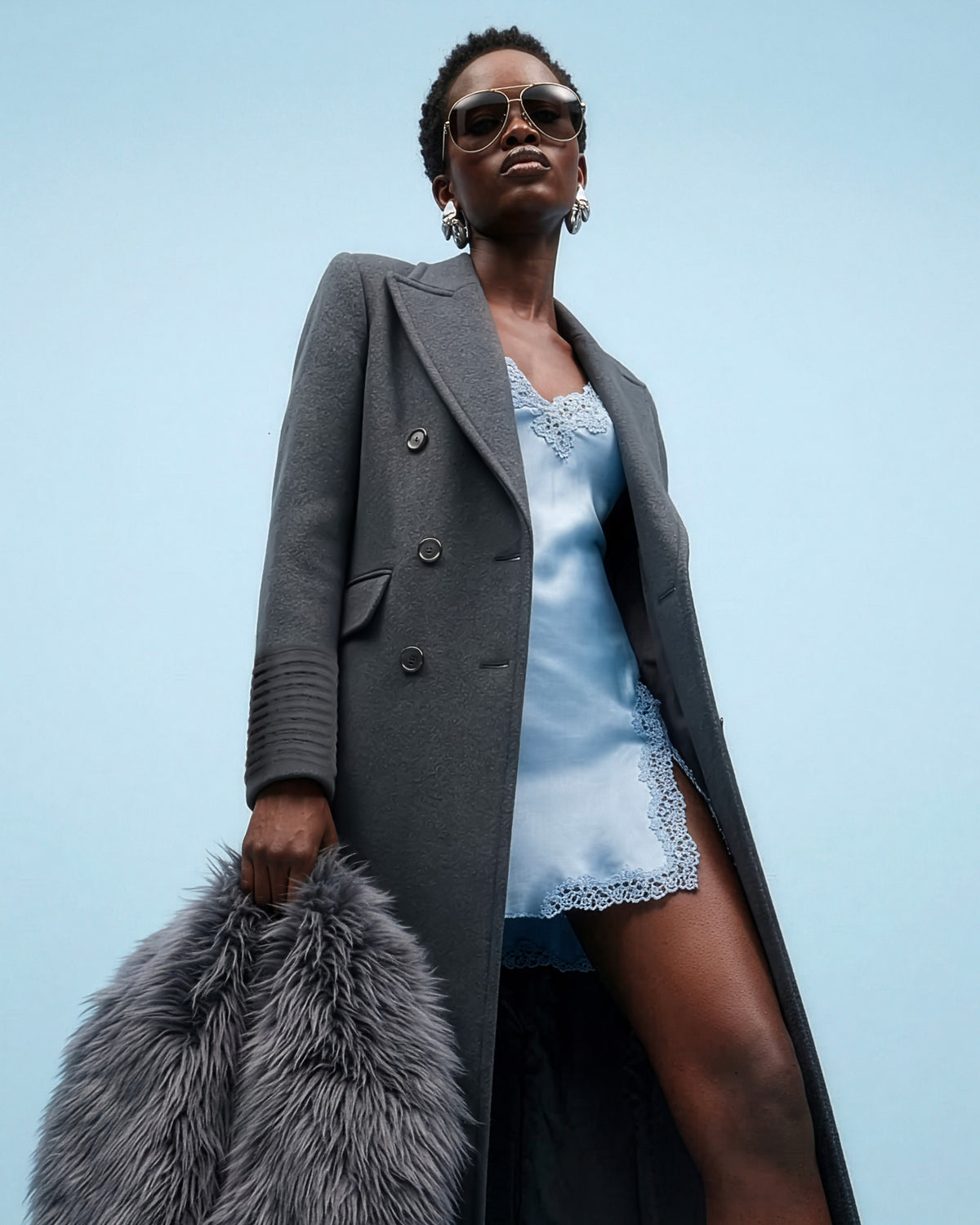 Front view of model wearing a Sentaler graphite double breasted maxi coat made of baby alpaca wool, with a peak collar, worn unbuttoned with shearling collar.