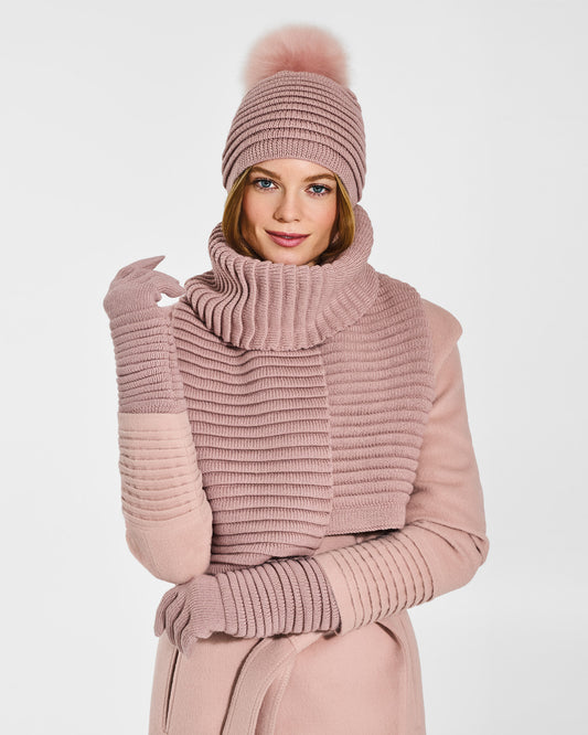 Front view of model wearing Sentaler's signature blush pink ribbed hat, scarf, and gloves, paired with a matching blush pink coat.