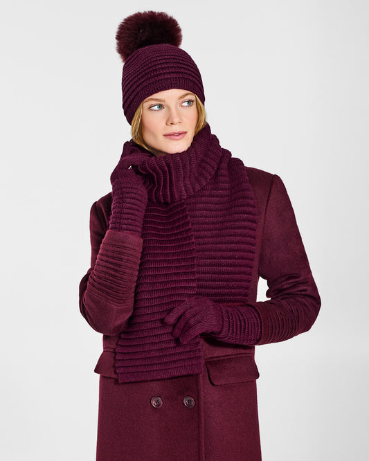 Front view of model wearing Sentaler's signature cherry lacquer ribbed hat, scarf, and gloves, paired with a matching cherry lacquer coat.