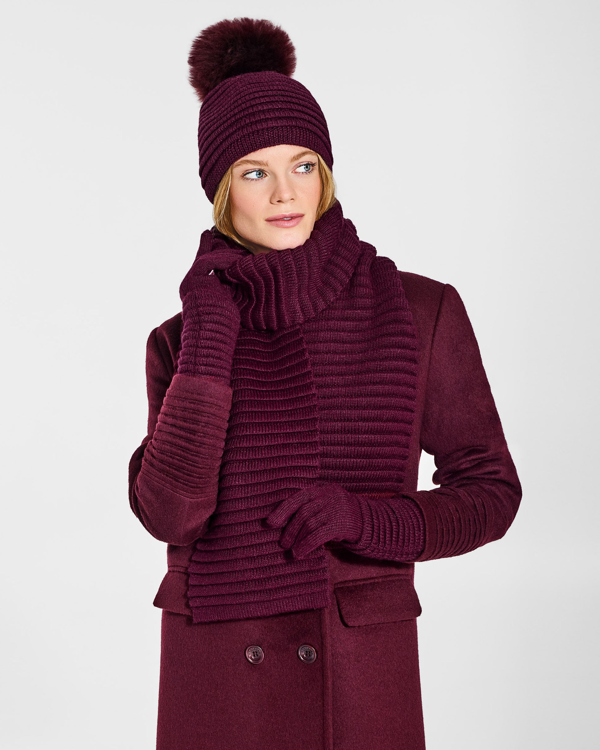 Front view of model wearing Sentaler's signature cherry lacquer ribbed hat, scarf, and gloves, paired with a matching cherry lacquer coat.