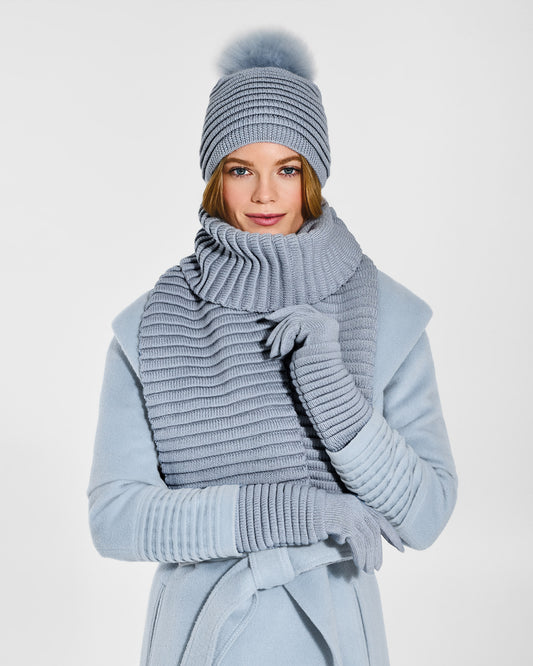 Front view of model wearing Sentaler's signature glacial blue ribbed hat, scarf, and gloves, paired with a matching glacial blue coat.
