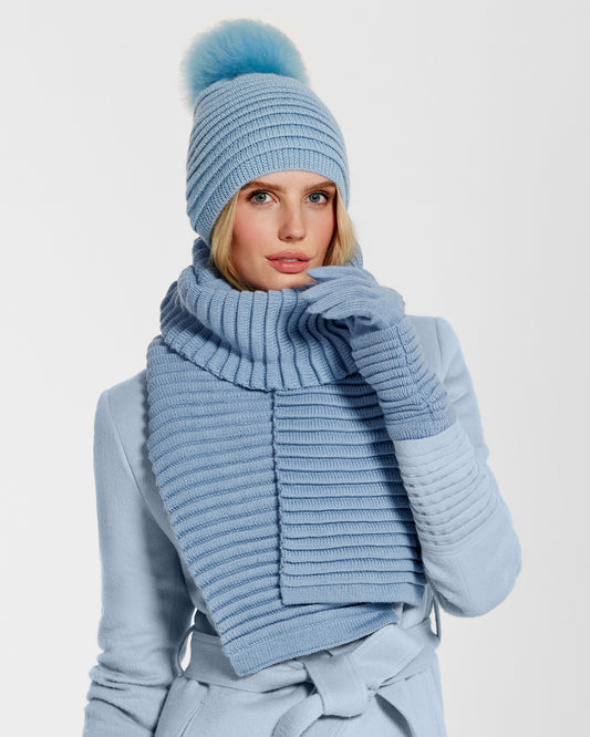Front view of model wearing Sentaler's adult powder blue ribbed gloves, made of baby alpaca yarn, paired with a powder blue coat.