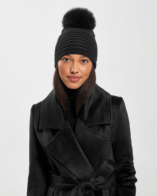 Sentaler Adult Ribbed Black Hat With Fur Pompon in Baby Alpaca yarn. Seen from front close up on female model.