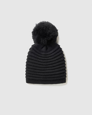 Sentaler women’s black ribbed winter hat made of Baby Alpaca fabric with oversized fur pompom, displayed on a white background.