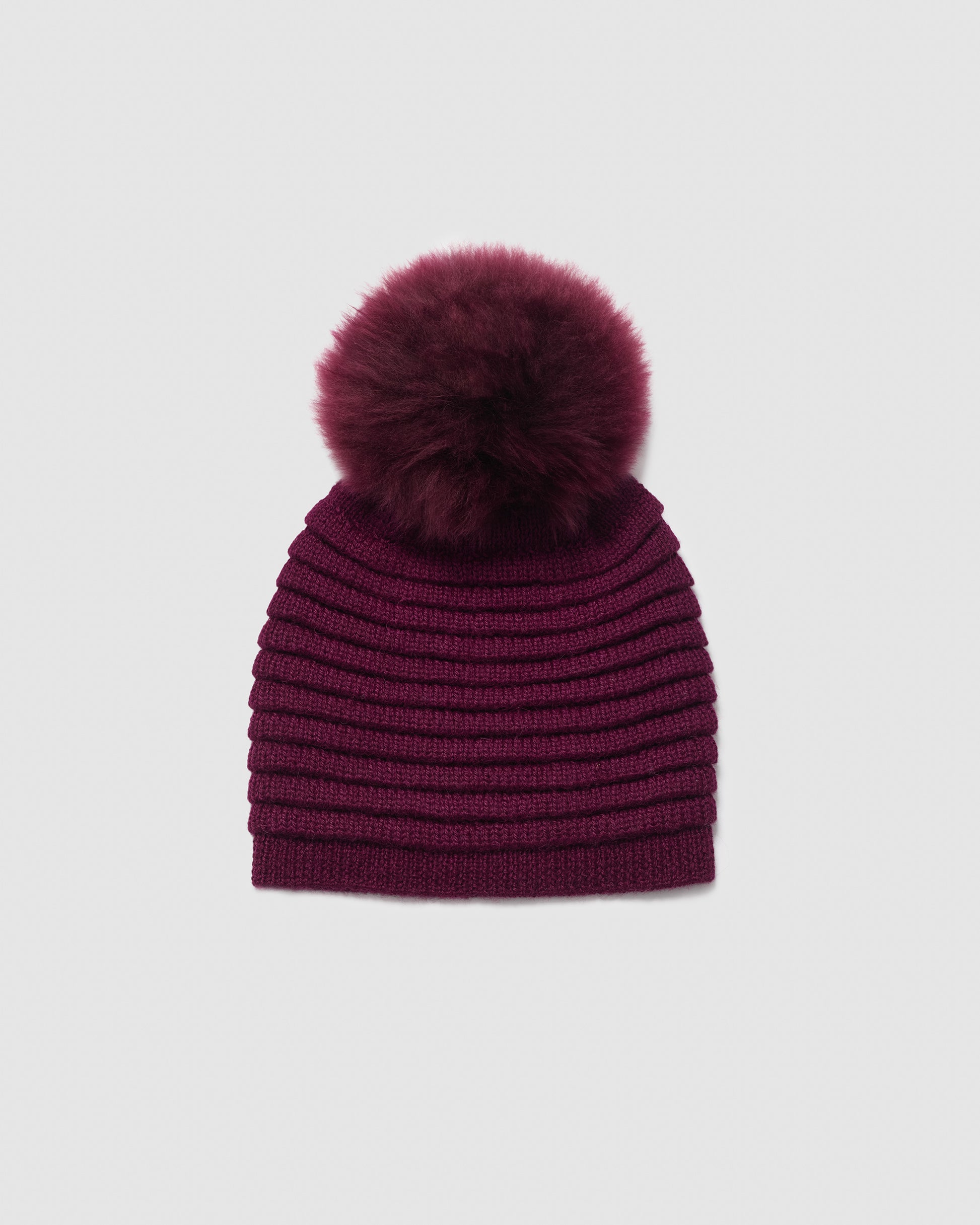 Sentaler women’s cherry lacquer ribbed winter hat made of Baby Alpaca fabric with oversized fur pompom, displayed on a white background.