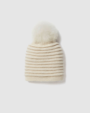 Sentaler women’s ivory ribbed winter hat made of Baby Alpaca fabric with oversized fur pompom, displayed on a white background.
