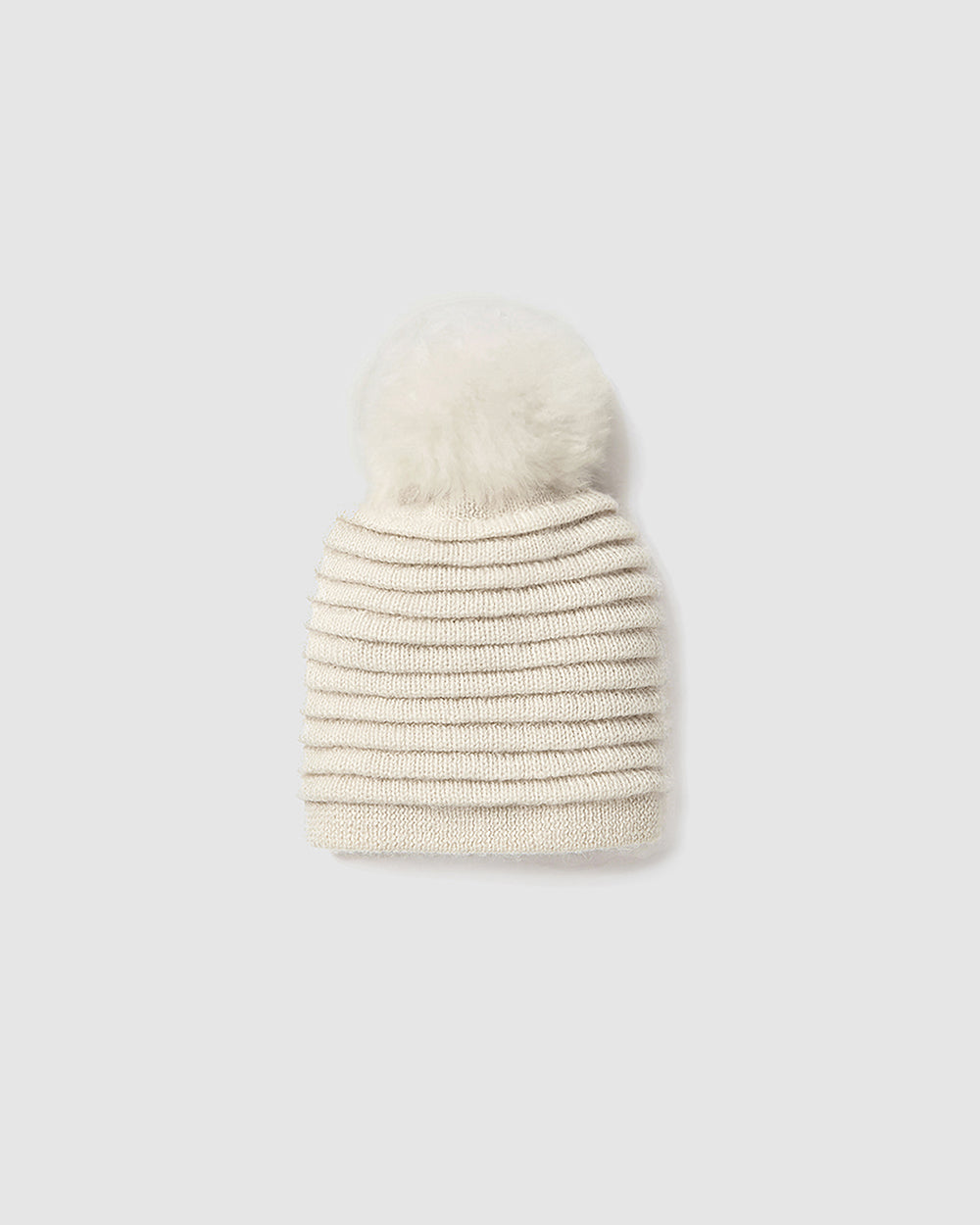 Sentaler Kids Ribbed Ivory Hat with Fur Pompon (6-14 Years) in Baby Alpaca yarn. Seen as off figure.