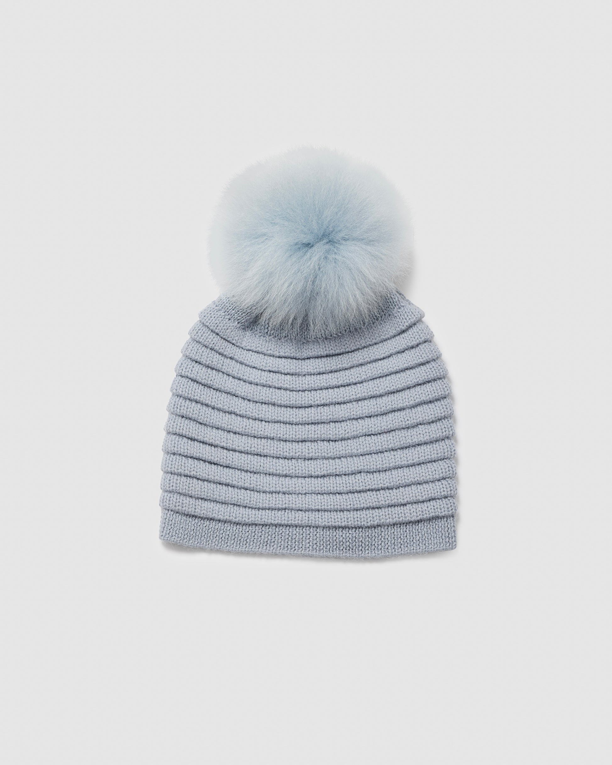 Sentaler women’s glacial blue ribbed winter hat made of Baby Alpaca fabric with oversized fur pompom, displayed on a white background.