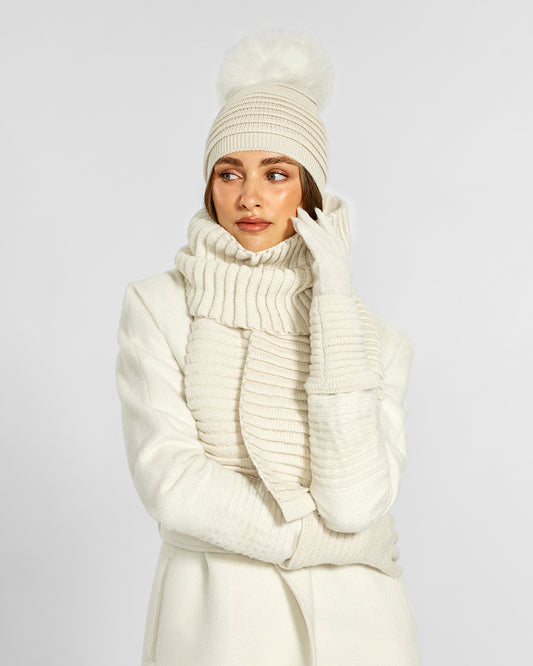 Sentaler Adult Ribbed Ivory Hat With Fur Pompon, Adult Ribbed Ivory Scarf, and Adult Ribbed Ivory Gloves in Baby Alpaca yarn. Seen from front close up on female model.