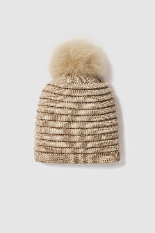 Sentaler Adult Ribbed Hat With Oversized Fur Pompon featured in Baby Alpaca and available in Camel. Seen as off figure.