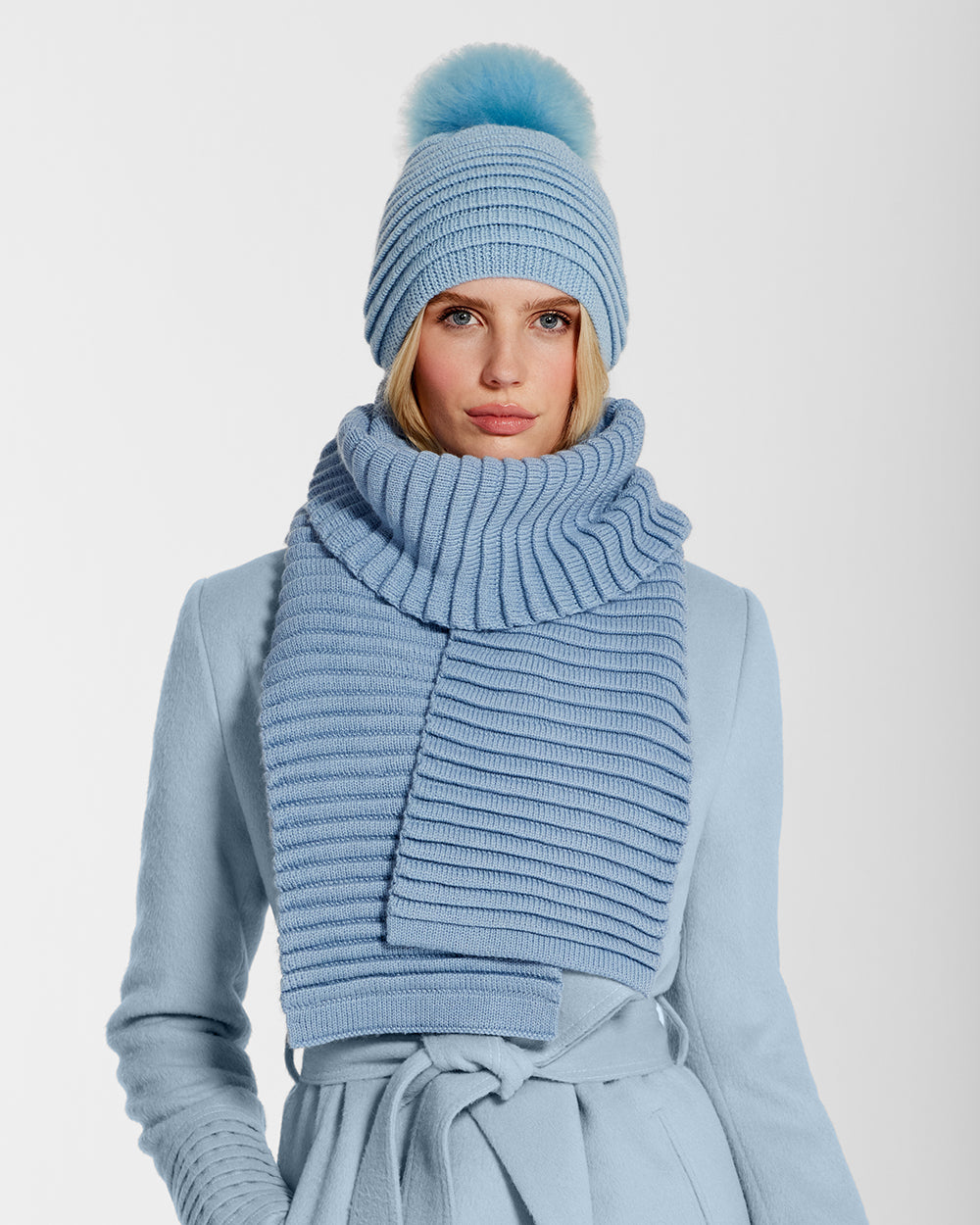 Sentaler Adult Ribbed Powder Blue Hat with Oversized Fur Pompon and Adult Ribbed Powder Blue Scarf in Baby Alpaca wool. Seen from front close up on female model.