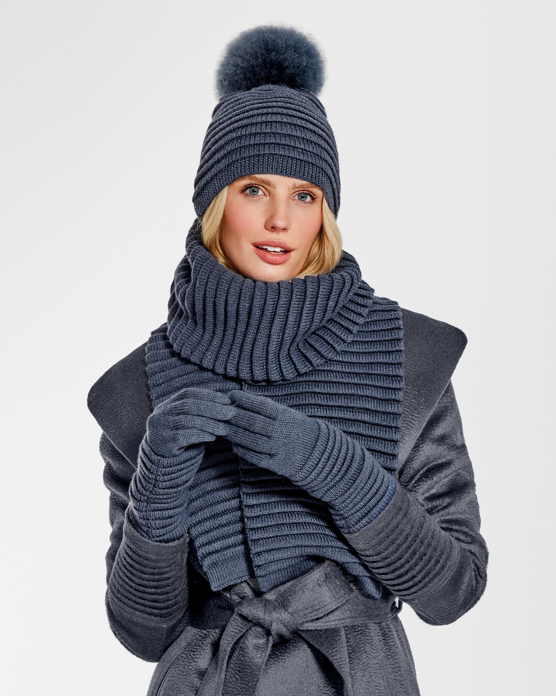 Front view of model wearing Sentaler's adult graphite ribbed scarf, made of baby alpaca yarn, paired with a graphite coat.