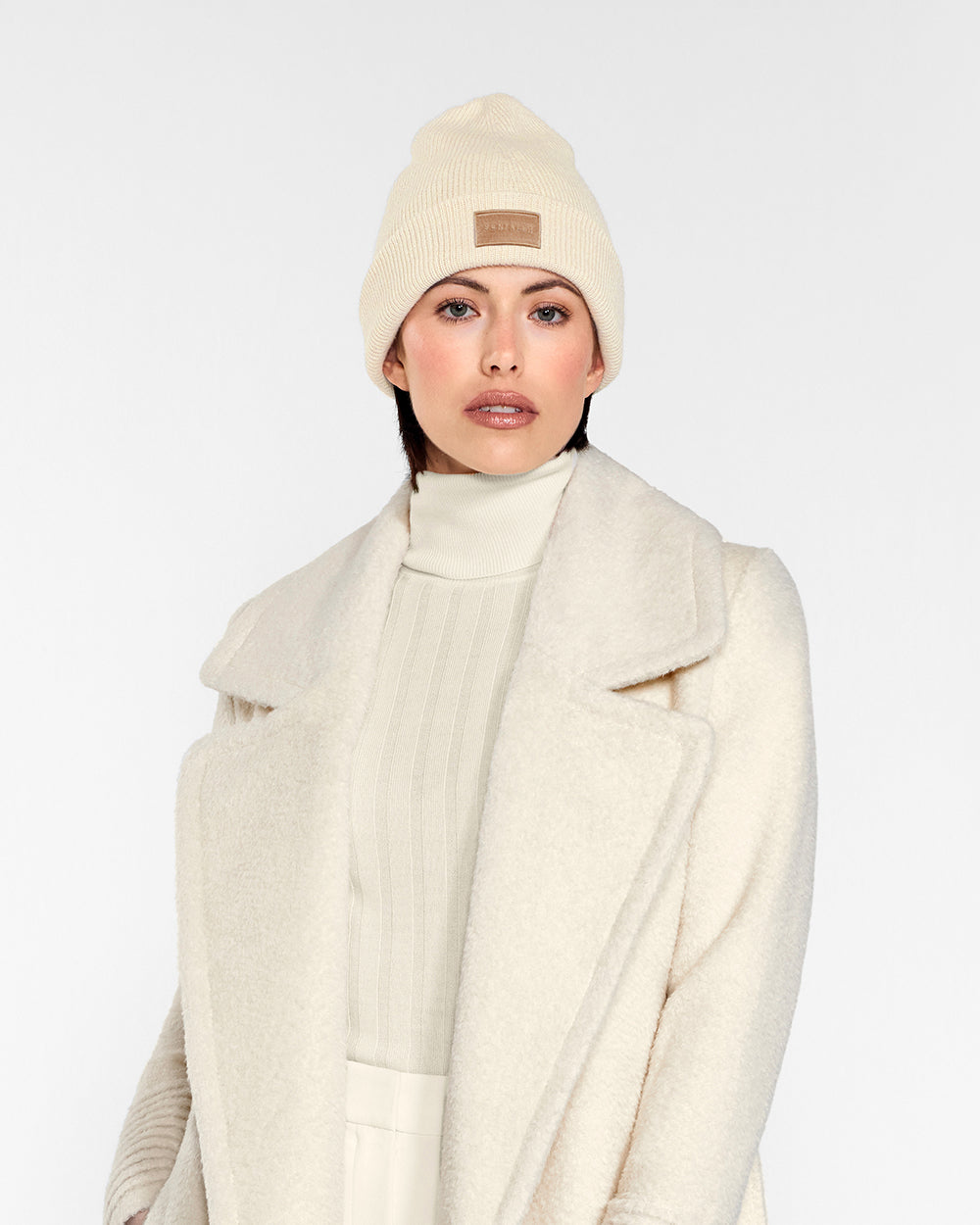 Sentaler Alpaca Beanie and the Bouclé Alpaca Long Notched Collar Wrap Coat crafted in Baby Alpaca and in Ivory White. Seen from front close up on female model.