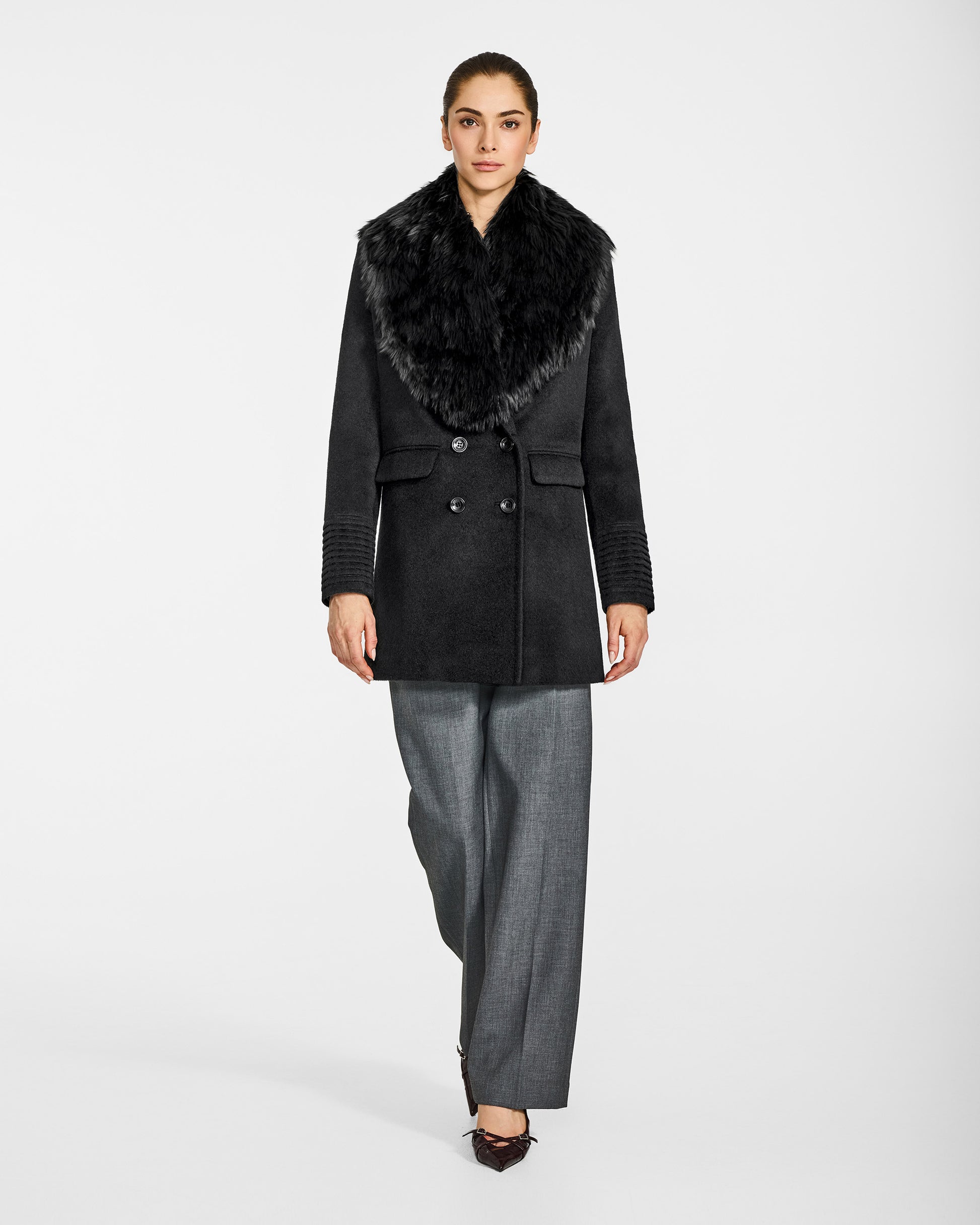 Front view of model wearing Sentaler's black alpaca shearling shawl collar, paired with a black coat.