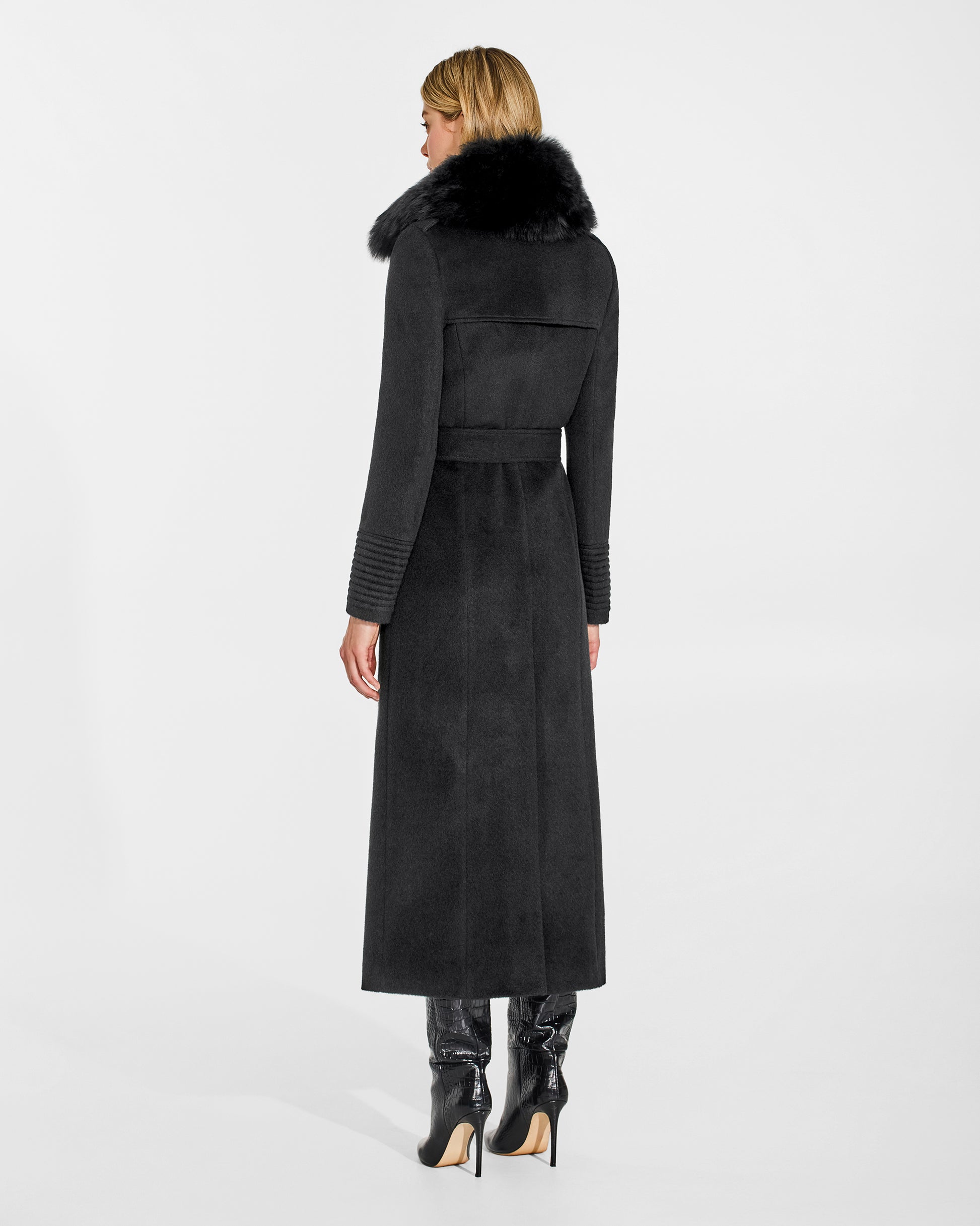 Back view of model wearing Sentaler's black alpaca shearling spread collar, paired with a black coat.