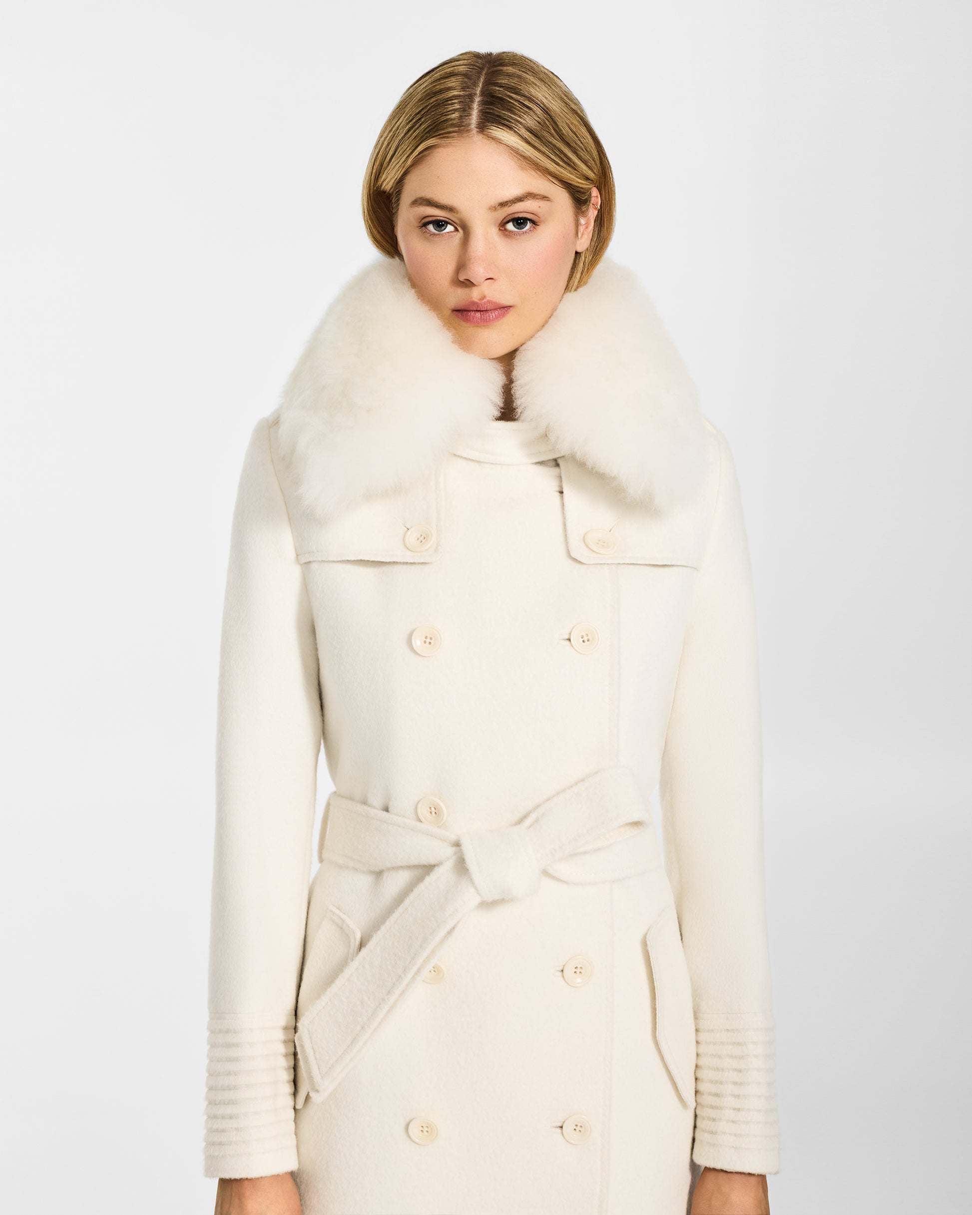 Front view of model wearing Sentaler's ivory alpaca shearling spread collar, paired with a ivory coat.