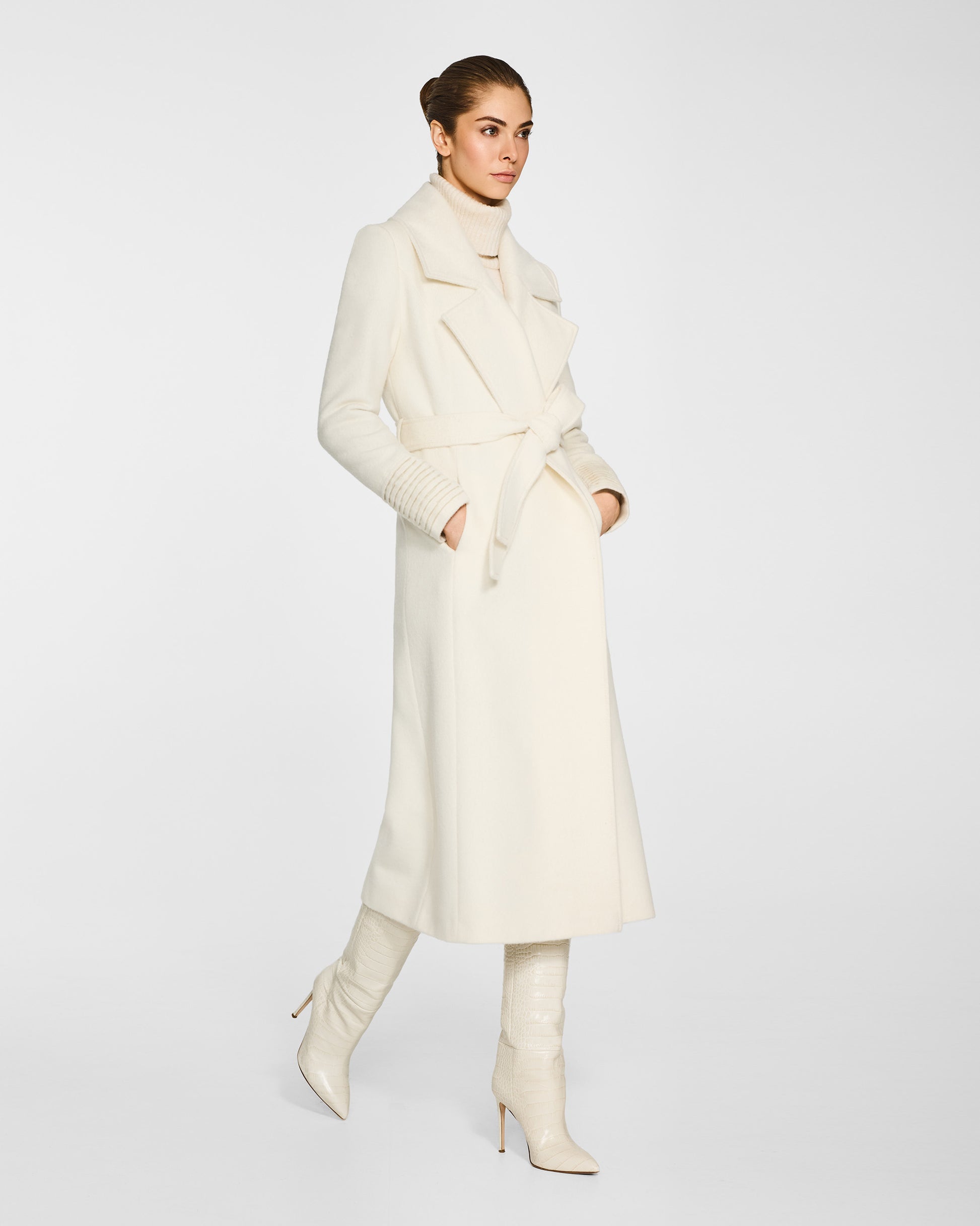 Side view of model wearing a SENTALER long ivory wrap coat made of baby alpaca wool, with a large notched collar, worn belted.