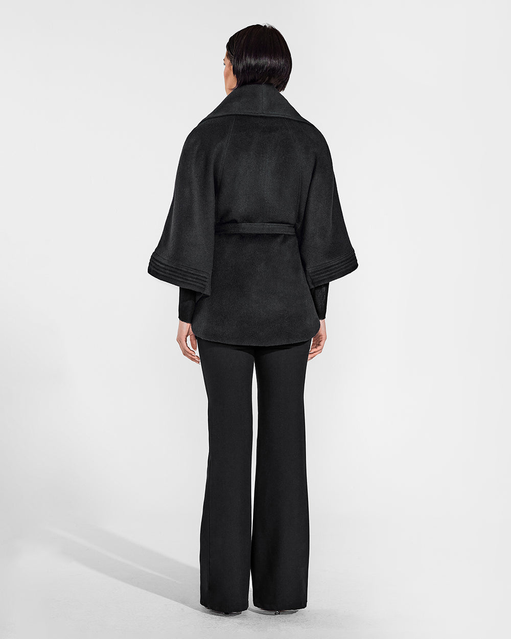 Sentaler Black Cape with Shawl Collar and Belt in Baby Alpaca wool. Seen from back belted on female model.