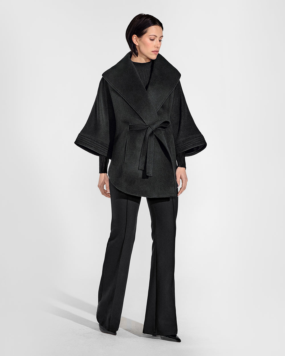 Sentaler Black Cape with Shawl Collar and Belt in Baby Alpaca wool. Seen from front belted on female model.