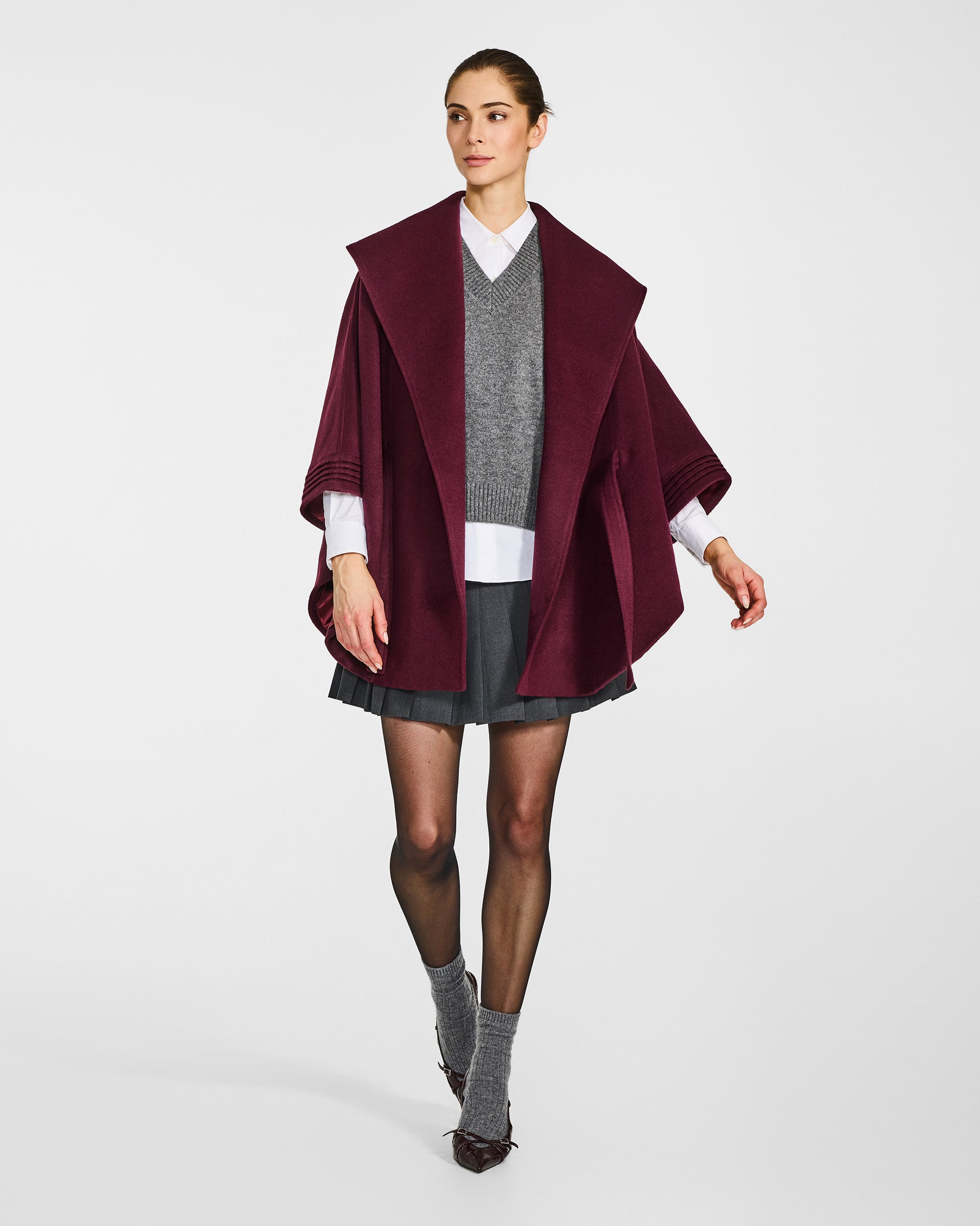 Front view of model wearing a Sentaler cherry lacquer cape made of baby alpaca wool, with a shawl collar, worn open.