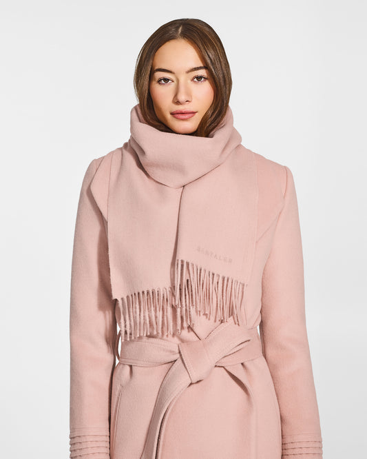 Front close-up view of model wearing Sentaler's adult Blush Pink classic scarf, made of baby alpaca yarn. 