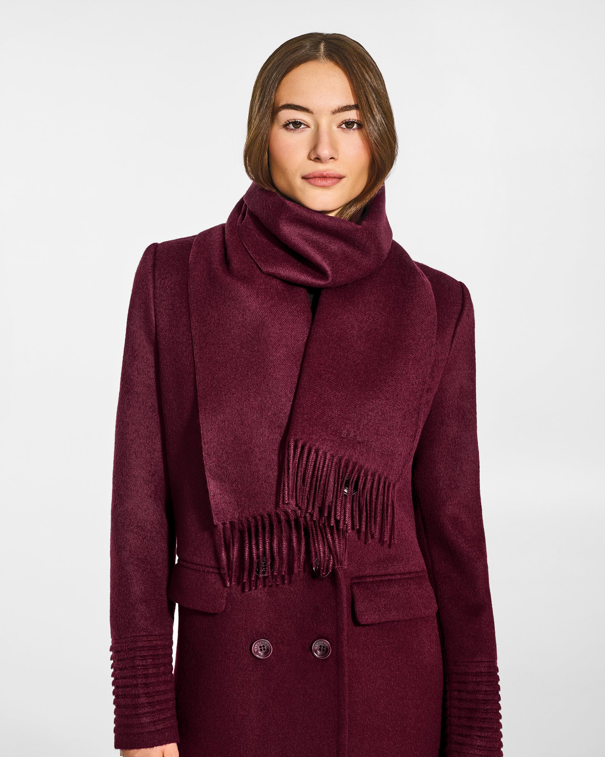 Front close-up view of model wearing Sentaler's adult Cherry Lacquer classic scarf, made of baby alpaca yarn. 