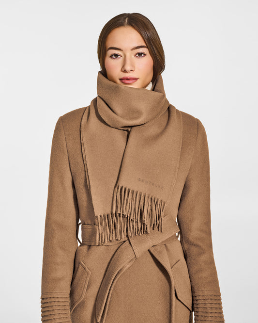 Front close-up view of model wearing Sentaler's adult Dark Camel classic scarf, made of baby alpaca yarn. 