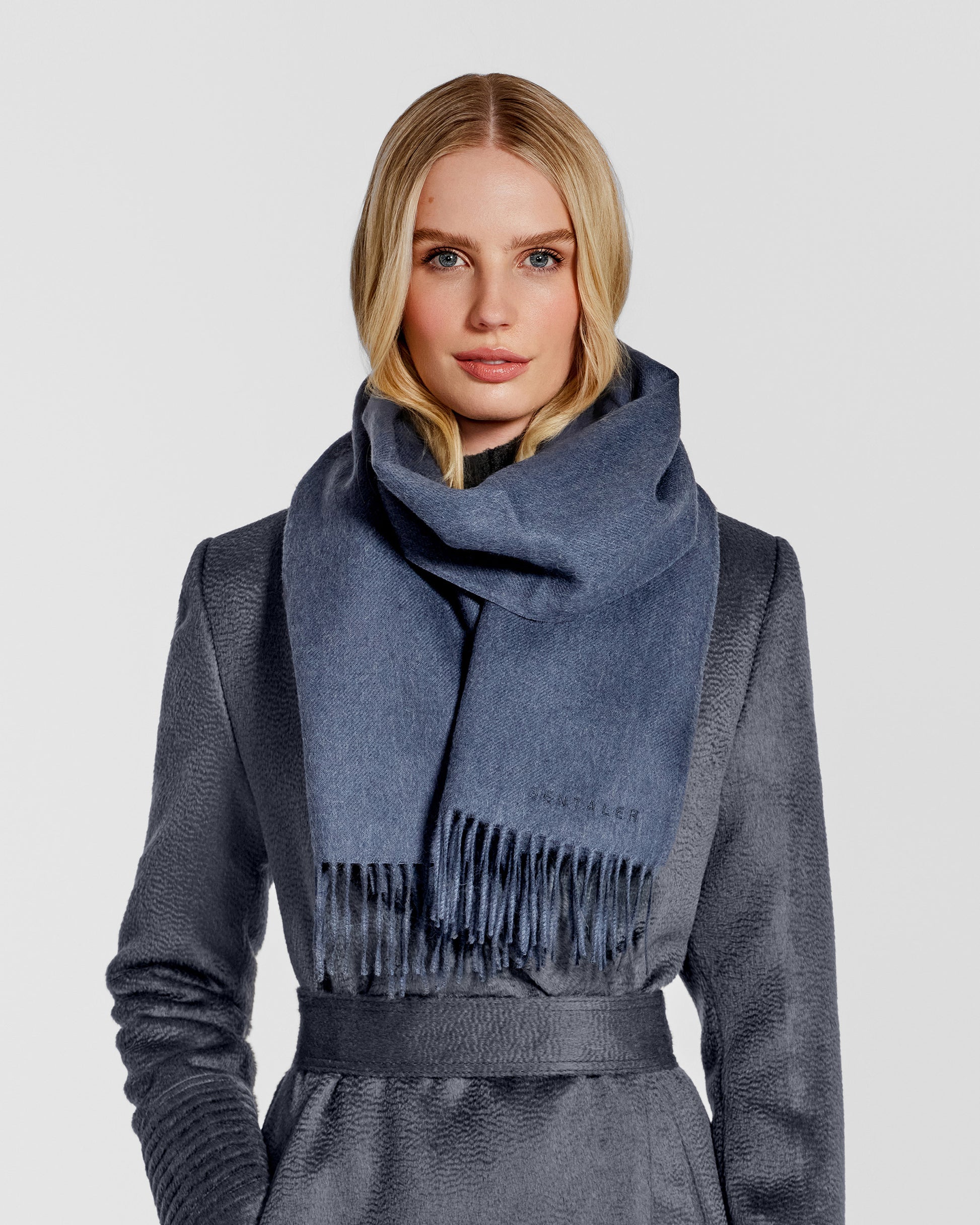 Front close up view of model wearing Sentaler's adult Graphite grey classic scarf, made of baby alpaca yarn. 