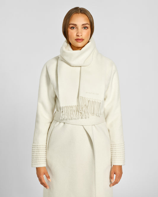 Front close up view of model wearing Sentaler's adult Ivory classic scarf, made of baby alpaca yarn. 