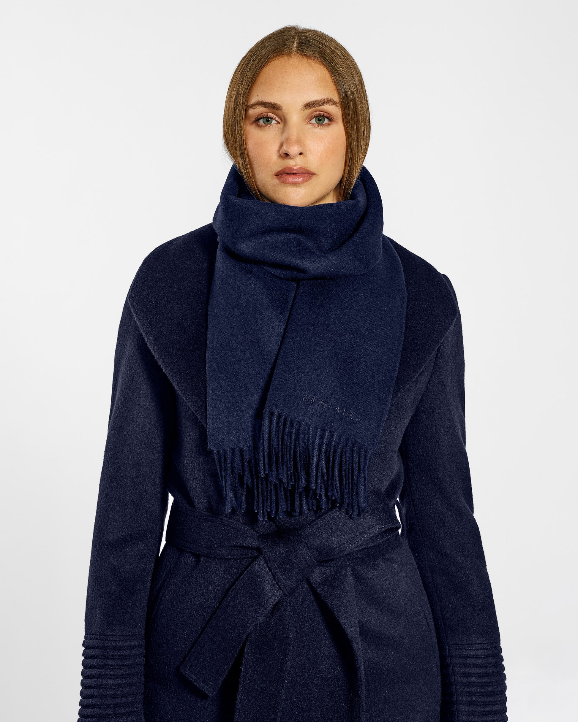 Front close up view of model wearing Sentaler's adult Navy classic scarf, made of baby alpaca yarn. 