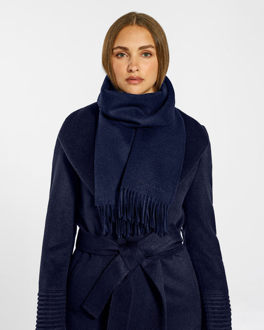 Front close up view of model wearing Sentaler's adult Navy classic scarf, made of baby alpaca yarn. 