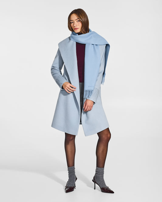 Front view of model wearing Sentaler's adult Powder Blue classic scarf, made of baby alpaca yarn. 