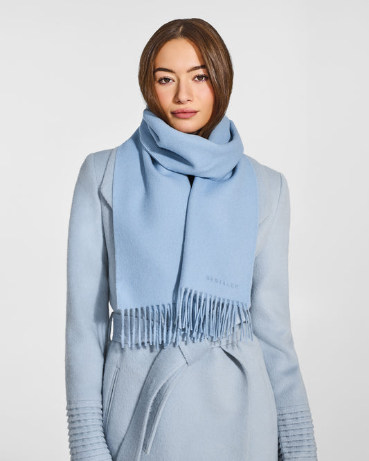 Front close up view of model wearing Sentaler's adult Powder Blue classic scarf, made of baby alpaca yarn. 