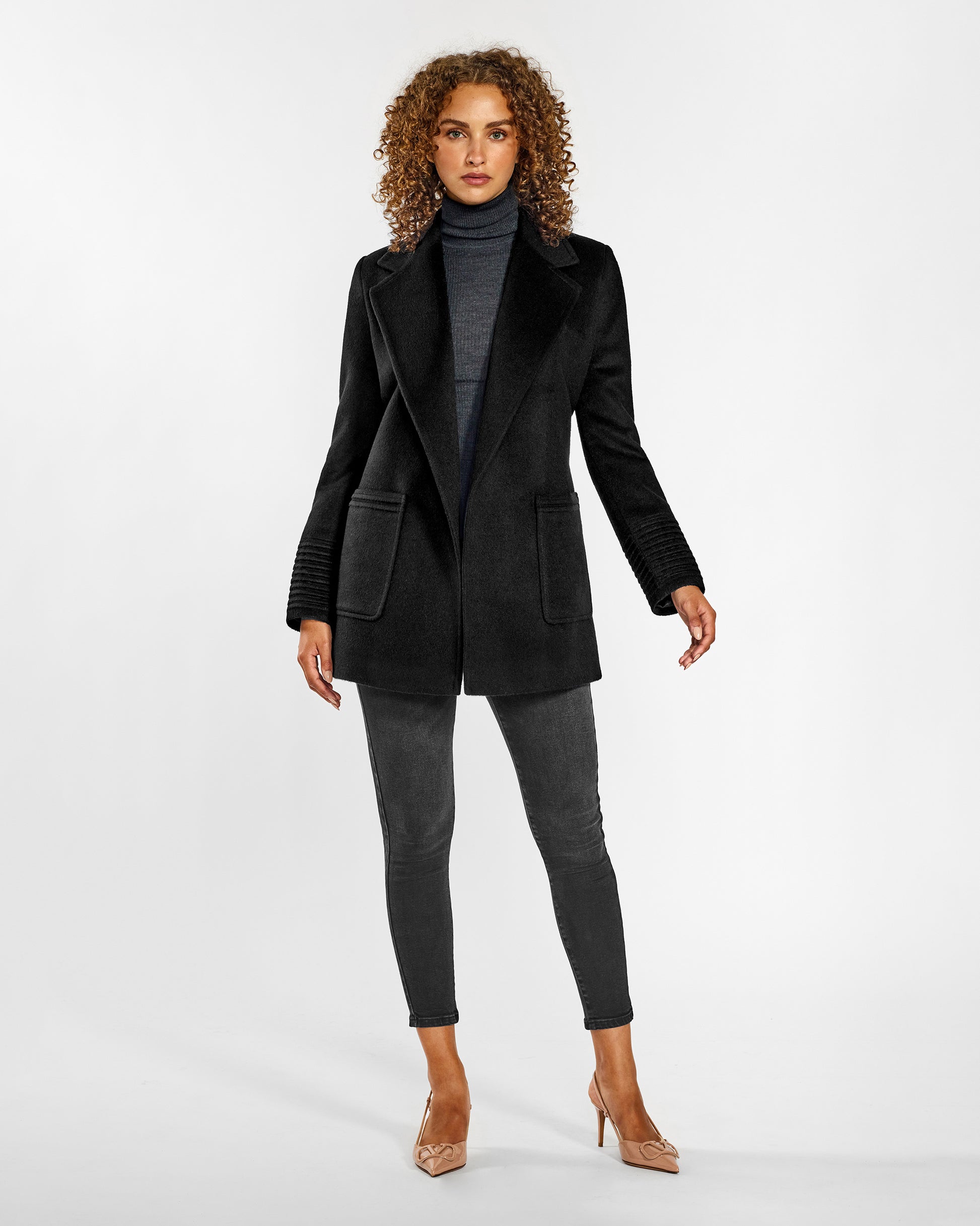 Front view of model wearing a SENTALER black cropped coat made of baby alpaca wool, with square pockets, worn open.
