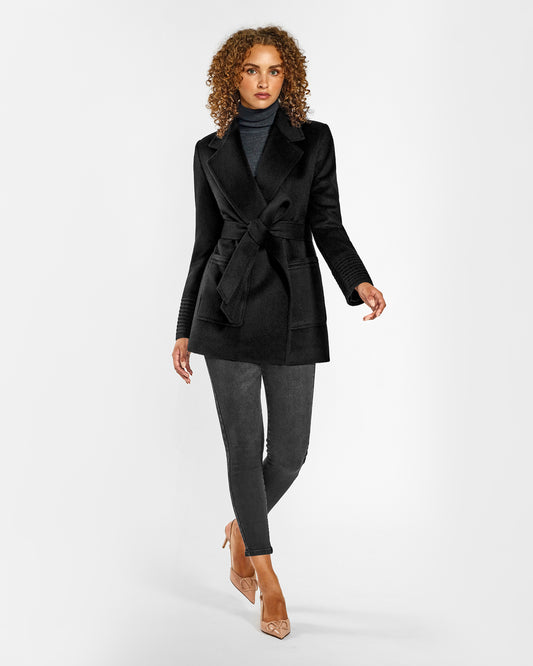 Front view of model wearing a SENTALER black cropped coat made of baby alpaca wool, with square pockets, worn belted.