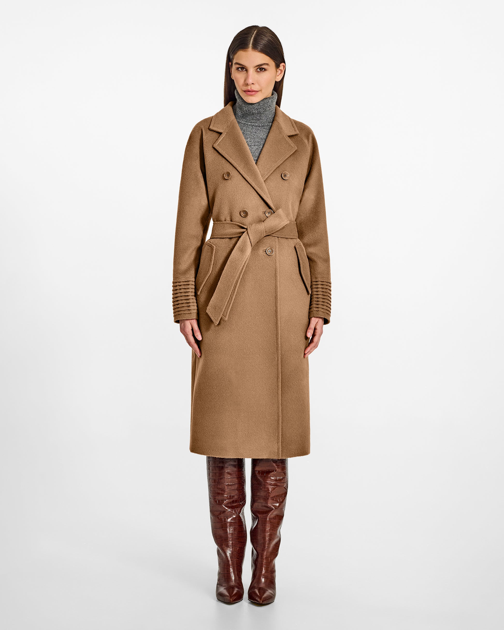Front view of model wearing a Sentaler dark camel double breasted coat made of baby alpaca wool, with a notched collar, worn belted.