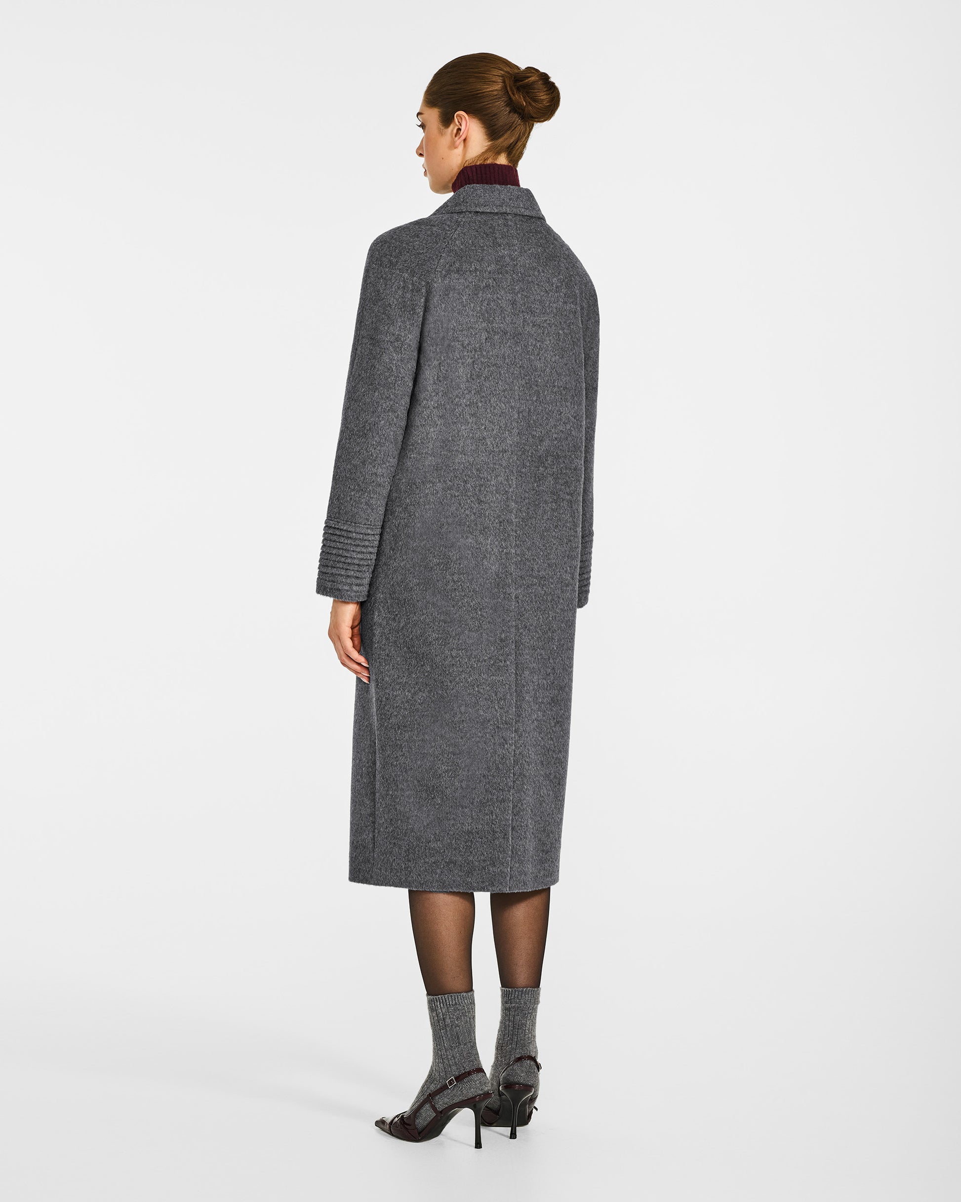 Back view of model in Sentaler grey mélange double breasted coat with notched collar in baby alpaca wool, button.