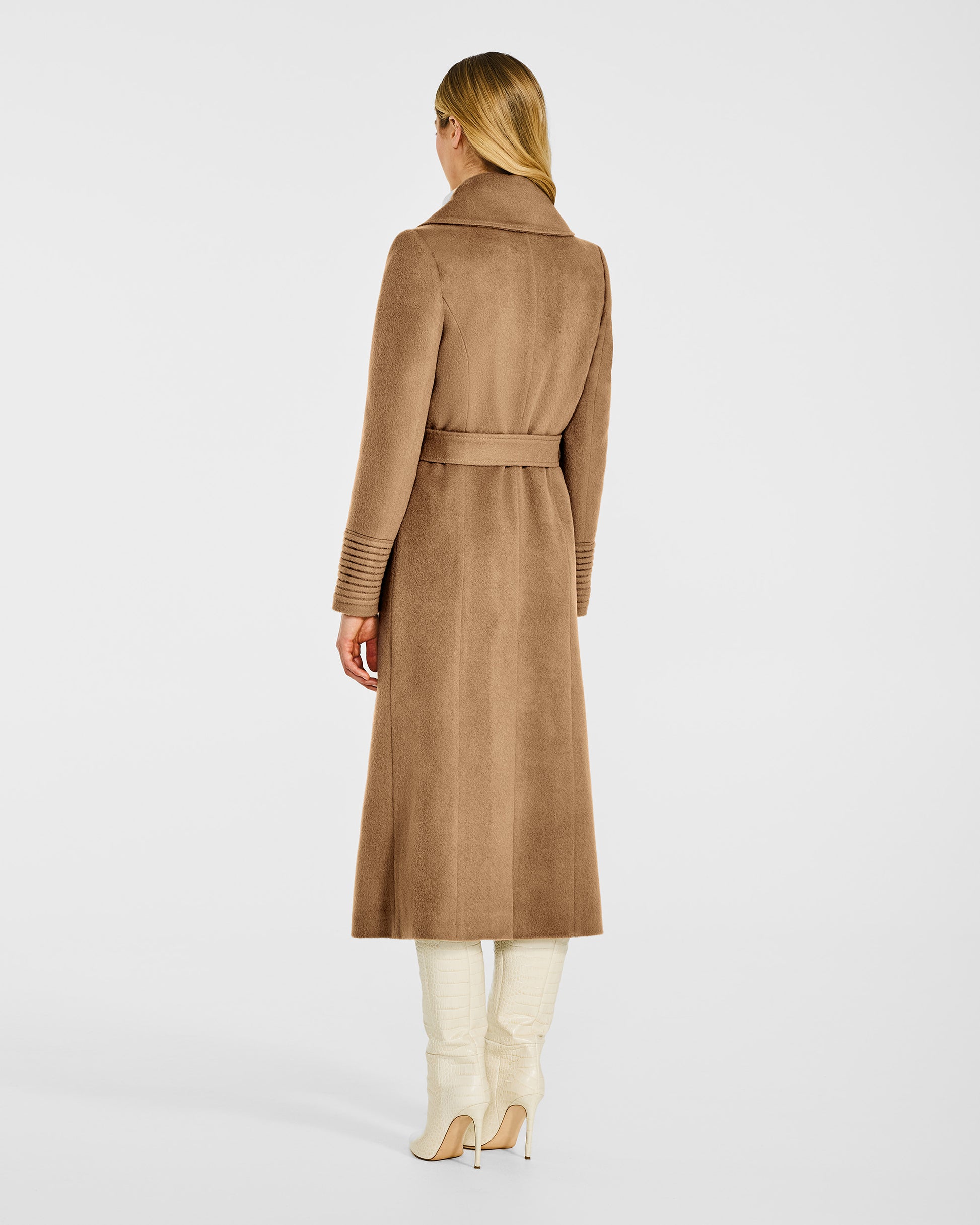 Back view of model wearing a SENTALER long dark camel wrap coat made of baby alpaca wool, with a large notched collar, worn belted.