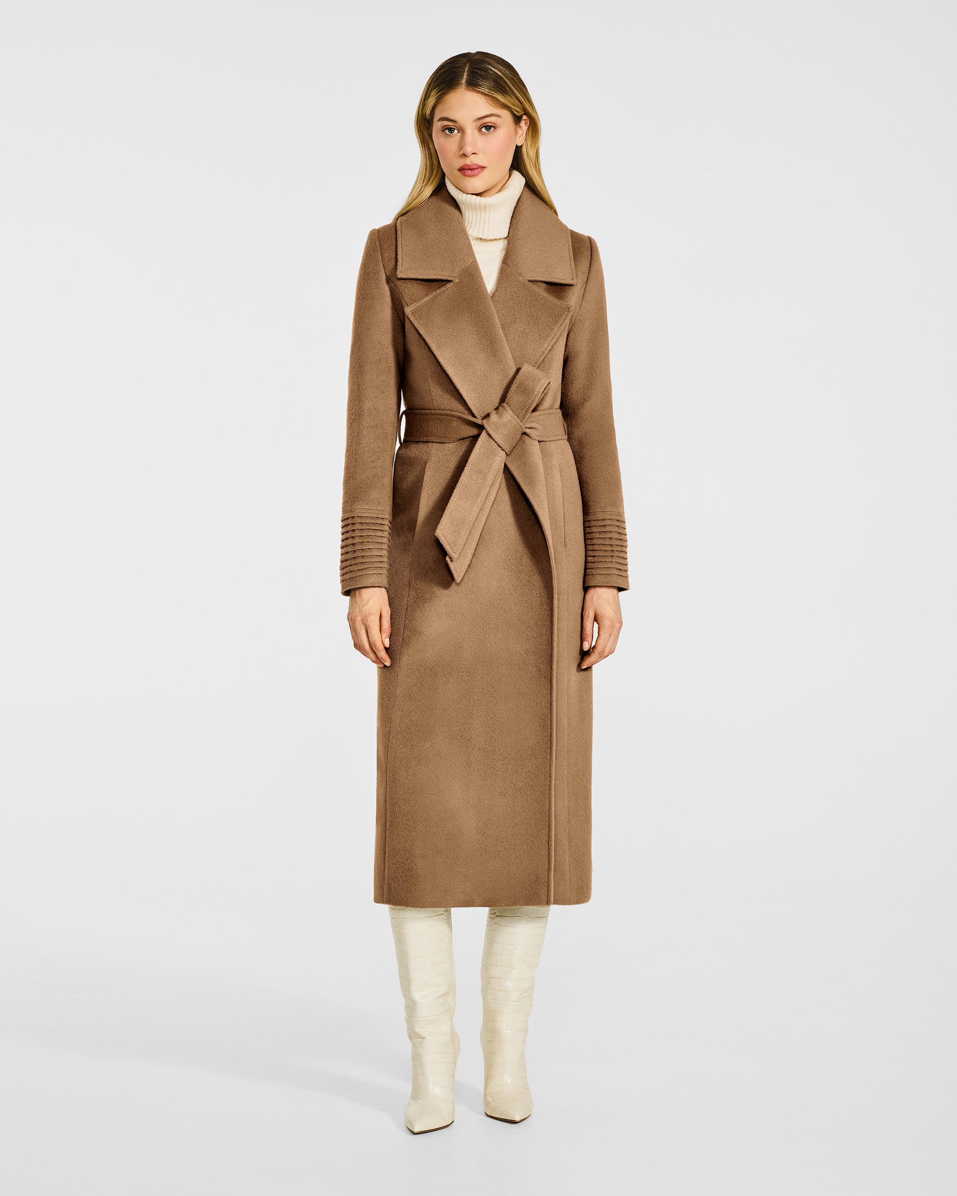 Front view of model wearing a SENTALER long dark camel wrap coat made of baby alpaca wool, with a large notched collar, worn belted.
